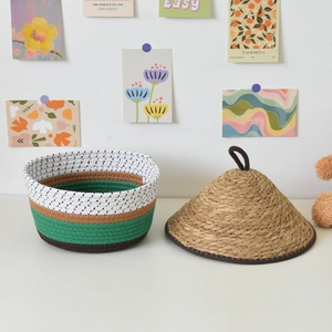 Detail of woven cotton rope storage basket with striped design and conical straw lid