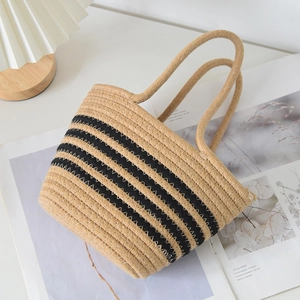 Détail d'un sac seau tissé à rayures avec poignées rondes sur un magazine d'art