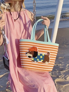 Detail of cute puppy embroidery on a striped woven tote bag for beach vacations
