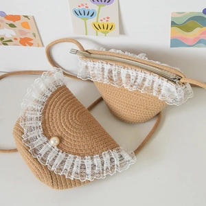 Detailed macro view of woven mini crossbody bag with delicate white lace and pearl button