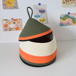 Detail of handcrafted cotton rope storage basket with pointed lid and color-block design