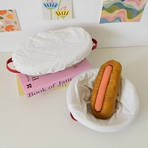 Close-up of woven bread proofing baskets with white linen liners and red handles