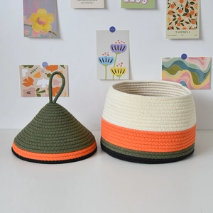 Detail of multi-color woven cotton rope basket with lid and loop handle for home storage