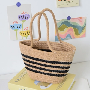 Détail d'un sac cabas tissé avec rayures noires sur texture en coton de couleur kaki