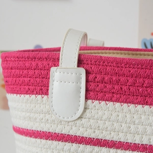 Detail of hand-woven tote bag showing pink stripes and reinforced white PU leather handle
