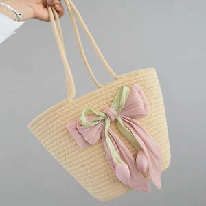 Detail of handmade straw tote featuring pink chiffon bow and tulip pendants decoration