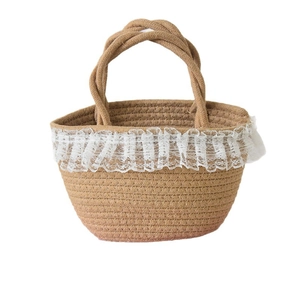 Handwoven straw bucket bag with white lace trim and rope handles for beach travel