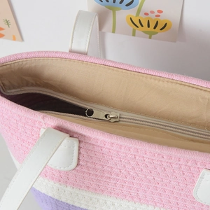 Detail view of the secure metal zipper closure and interior lining of the woven tote bag