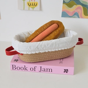 Oval woven proofing basket with white cotton liner and red faux leather handles
