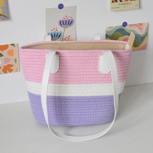 Close-up of pink and purple woven tote bag with white faux leather handles and inner lining