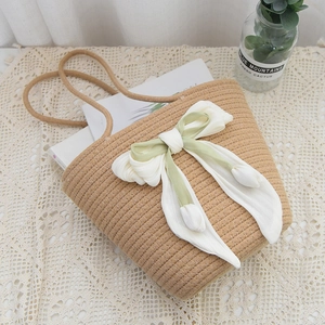 Handmade rainbow straw woven tote bag with a large green silk bow for beach vacations