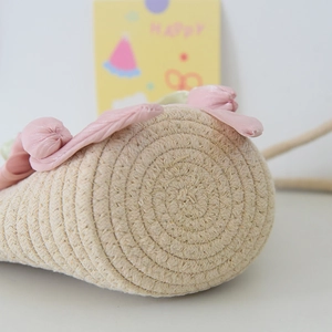 Close-up of the woven cotton rope bottom and pink tulip flower decor on the bucket bag