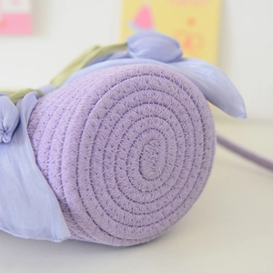 Close-up of the tightly woven spiral base of this tulip-style purple cotton rope bucket bag