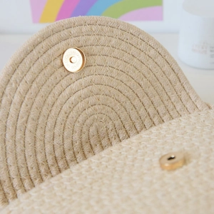 Detail view of woven cotton tote bag featuring a golden magnetic closure and spiral weave texture