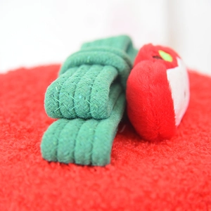 Macro shot of green woven texture and red plush ornament for dachshund basket lid