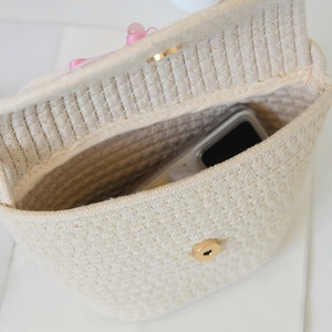 Detail view of woven cotton tote bag interior with magnetic clasp and decorative ribbon