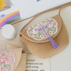 Close-up of handwoven cotton tote bag featuring floral embroidery and tassel details