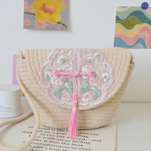 Detailed embroidery with pink flower tassels and Chinese knots on a woven tote bag