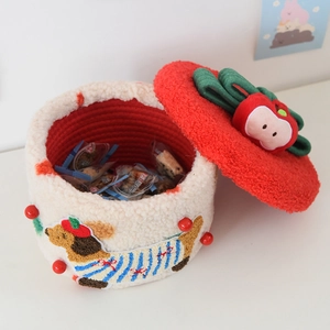 Close-up of cream dachshund storage basket with red woven liner and festive apple charm