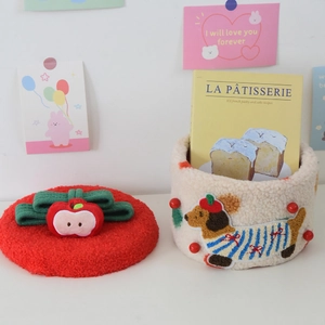 Detail of dachshund embroidery on cream sherpa fleece storage box with red apple lid