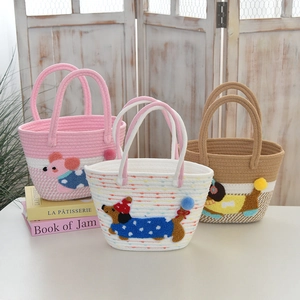 Close-up of woven tote bags featuring colorful cartoon animal embroidery and cotton rope textures