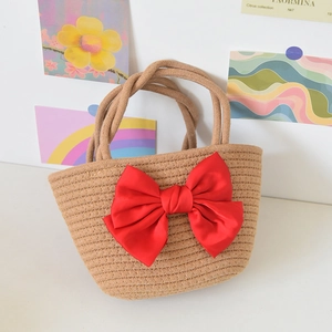 Detail of woven straw handbag with a large red satin bow for beach or gift use