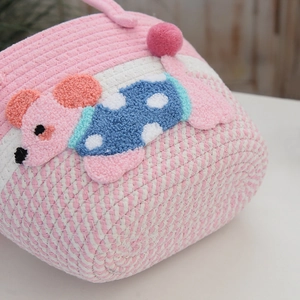Close-up of woven cotton tote bag showing pink texture and 3D chenille cartoon animal patch