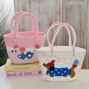 Close-up of woven cotton tote bags featuring cute cartoon animal patches and braided handles