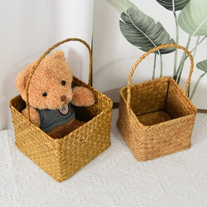 Detail showing the sturdy texture and curved handle of two square woven flower baskets
