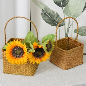 Detail of square seagrass flower baskets with arched handles and woven texture