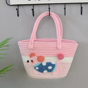 Detailed weave of pink gradient tote bag with cute cartoon puppy patchwork and pom-pom