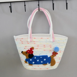 Detail of hand-woven straw tote featuring a cute cartoon dachshund patch with color accents