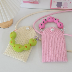 Close-up of woven mini crossbody bags featuring pearl clasp and embroidered colorful handles