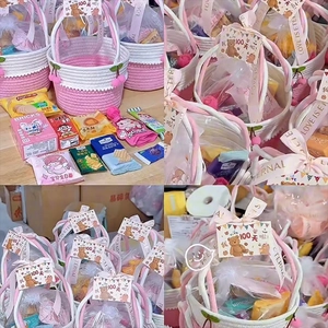 Close-up of pink cherry woven cotton basket with baby's 100 days gift card and snacks