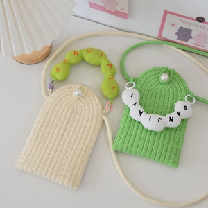 Detail view of woven pearl phone bags in cream and green with textured wave patterns