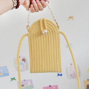 Detail of yellow woven mobile phone bag featuring a large pearl button and pearl strap