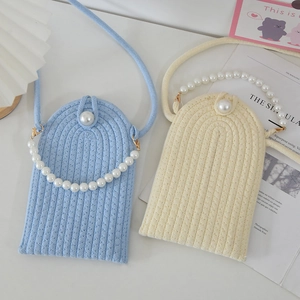 Detail of hand-woven phone bags with pearl handles in blue and beige cotton rope