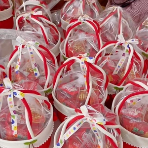 Top view of red and white woven gift baskets with cherry charms and assorted snacks