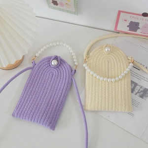 Detailed texture of woven phone bag with large pearl clasp and matching braided straps