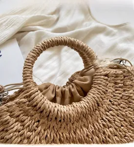 Close-up of hand-woven straw tote bag with round handle and secure drawstring liner