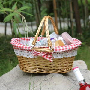 Handwoven willow picnic basket with red checkered lining and white lace bow detail