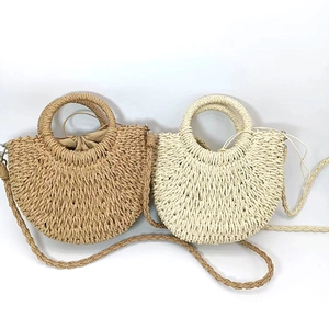 Top view of woven half-moon straw bags in tan and cream with drawstring lining