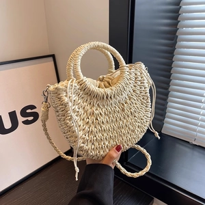 Detail view of woven straw tote bag with ring handle and detachable shoulder strap