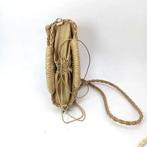 Detail view of woven straw bag with khaki fabric drawstring liner and interior capacity