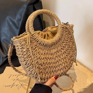 Handwoven straw half-moon beach bag with round handles and secure drawstring liner