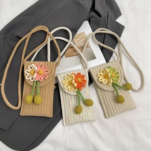Detailed close-up of handmade woven mini phone bags with 3D floral accents and tassels