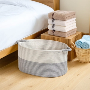Detailed macro view of dual-tone cotton rope storage basket with woven handles in bedroom