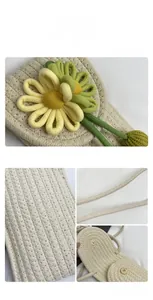 Close-up of woven crossbody phone bag with floral applique and gold magnetic closure
