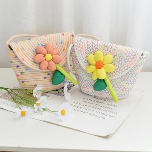 Detail of hand-woven mini straw bags with large floral 3D decor for girls and summer beach
