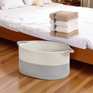 Detail of a large woven cotton rope storage basket with white and grey dual-tone stitching